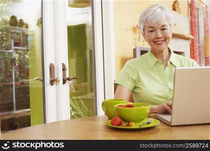 Portrait of a senior woman using a laptop and smiling
