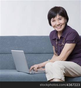 Portrait of a senior woman using a laptop and smiling