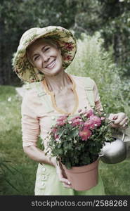 Portrait of a senior woman watering in a potted plant and smiling