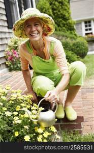 Portrait of a senior woman watering plants and smiling