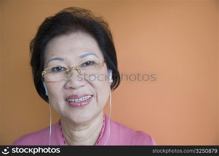 Portrait of a senior woman wearing earbuds and smiling
