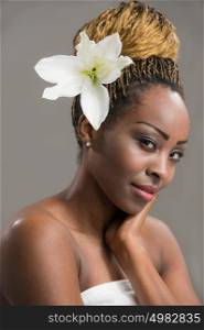 Portrait of a sensual young African woman with lily flower in hair