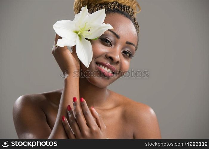 Portrait of a sensual young African woman with lily flower in hair