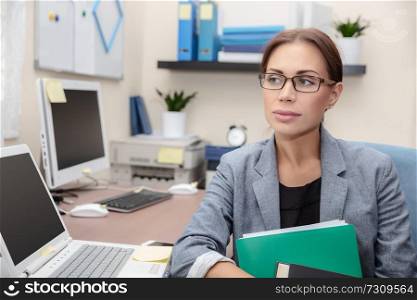 Portrait of a serious business woman with documents in hands sitting in the office, makes a career in the finance industry, smart people and hard work concept, female entrepreneur