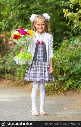 portrait of a seven-year first-grade girl with a bouquet of flowers