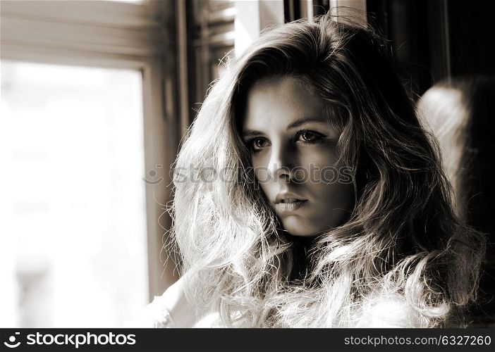 Portrait of a sexy blonde woman, model of fashion, in window