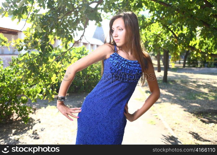 Portrait of a sexy young female in a park in blue dress