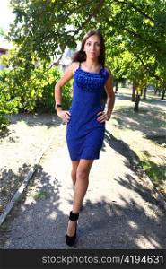 Portrait of a sexy young female in a park in blue dress