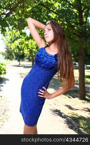 Portrait of a sexy young female in a park in blue dress