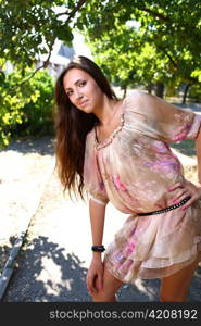 Portrait of a sexy young female in a park in sexy short dress