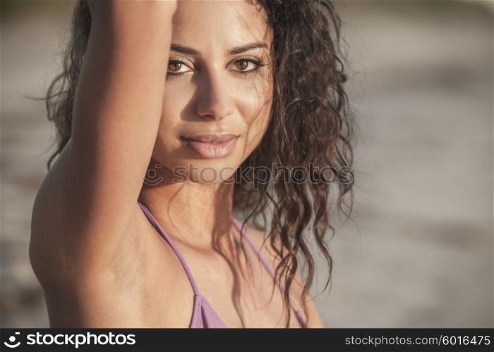 Portrait of a sexy young Latina Hispanic brunette woman or girl wearing a bikini on a tropical beach