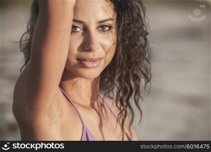 Portrait of a sexy young Latina Hispanic brunette woman or girl wearing a bikini on a tropical beach