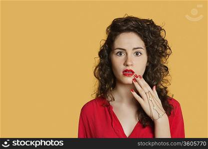 Portrait of a shocked woman over colored background
