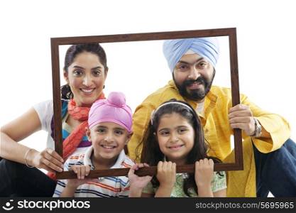 Portrait of a Sikh family through a wooden frame