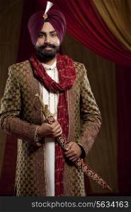 Portrait of a Sikh groom holding a sword