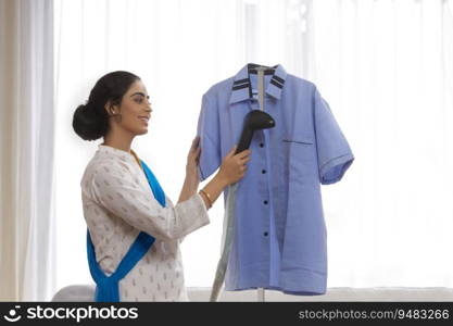 Portrait of a single woman ironing shirt at home. 