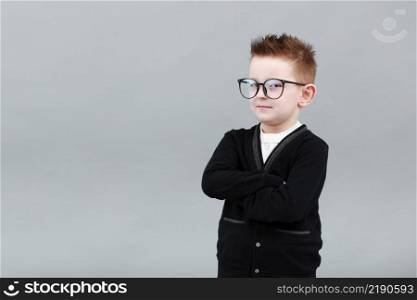 Portrait of a smart childe boy in glasses on a grey background close-up, folded his arms over his chest. Concept of school education, science and innovation, business development. Portrait of a smart childe boy in glasses on a grey background close-up, folded his arms over his chest. Concept of school education, science and innovation, business development.