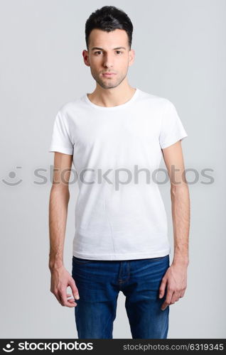 Portrait of a smart serious young man standing against white background