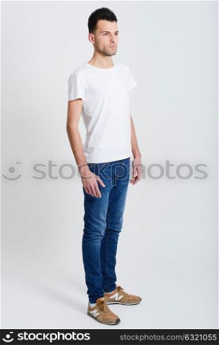 Portrait of a smart serious young man standing against white background