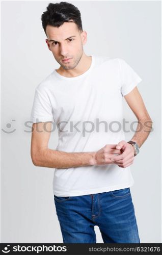 Portrait of a smart serious young man standing against white background