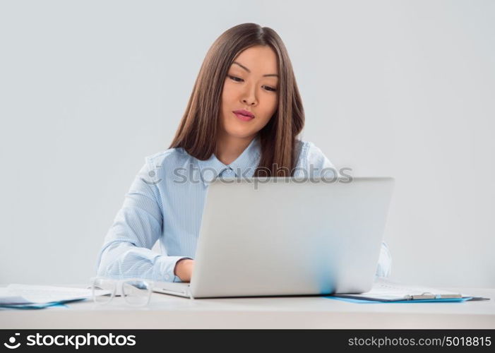 Portrait of a smiling beautiful young business woman working on laptop