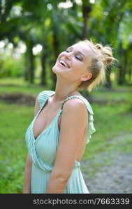 Portrait of a smiling blond lady in a rainforest