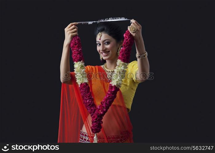 Portrait of a smiling bride holding a garland