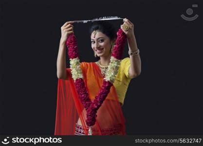 Portrait of a smiling bride holding a garland