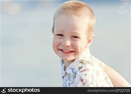 portrait of a smiling child on the background of the sea