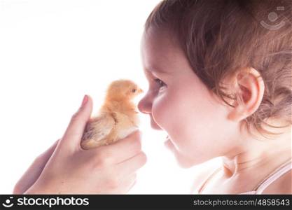 Portrait of a smiling child who is happy seeing little chickens. Close-up. Happy child and little chicken