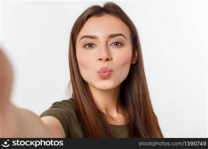 Portrait of a smiling cute woman making selfie photo on smartphone isolated on a white background. Portrait of a smiling cute woman making selfie photo on smartphone isolated on a white background.