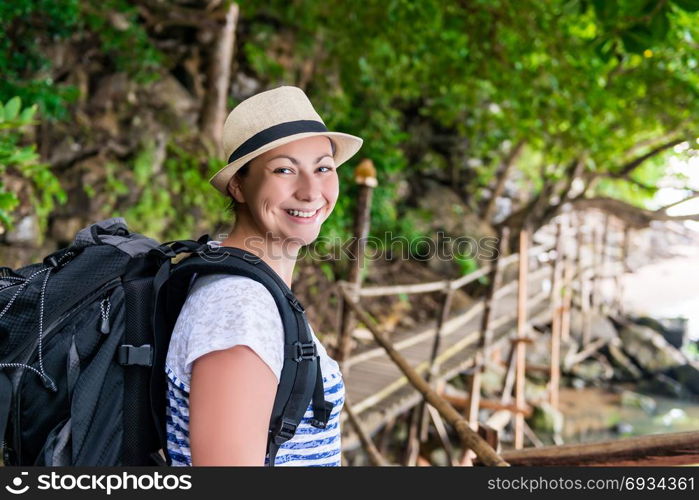 portrait of a smiling happy woman with a backpack hiking in the journey