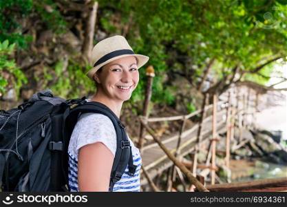 portrait of a smiling happy woman with a backpack hiking in the journey