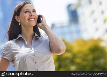 Portrait of a smiling happy young woman or businessowman talking on her cell phone