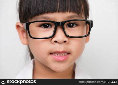 Portrait of a smiling little girl wearing glasses in a doctor or science costume on a white background. Little scientist.