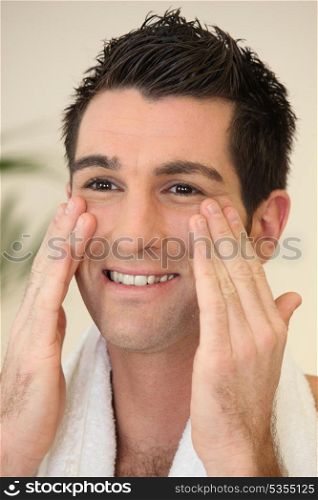 Portrait of a smiling man applying cream