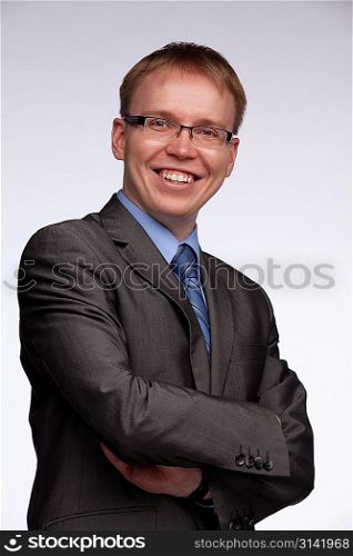 Portrait of a smiling man with crossed arms on glaucous background