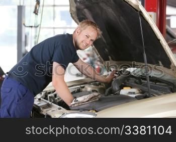 Portrait of a smiling mechanic working on a car in garage