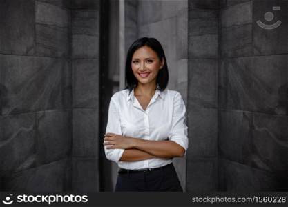 Portrait of a Smiling Mixed Races Business Woman, Crossed Arm and Look into the Camera