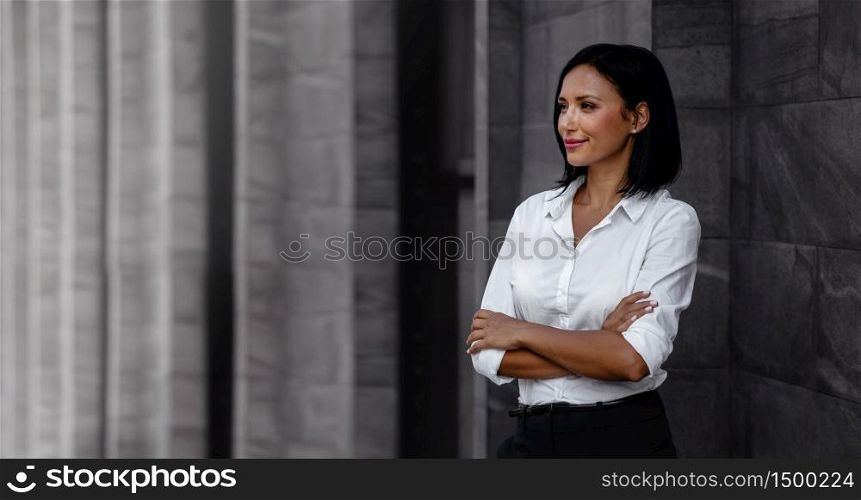 Portrait of a Smiling Mixed Races Business Woman, Crossed Arm and Looking away in Urban City