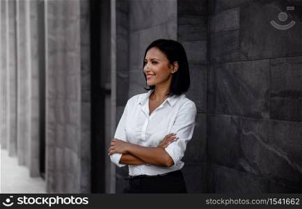 Portrait of a Smiling Mixed Races Business Woman, Crossed Arm and Looking away in Urban City