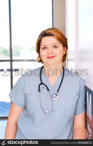 Portrait of a smiling nurse standing in a hospital corridor