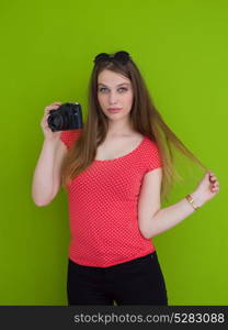 portrait of a smiling pretty girl taking photo on a retro camera isolated over green background