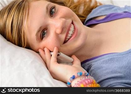 Portrait of a smiling teenager girl talking on her phone