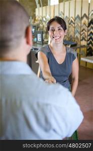 portrait of a smiling woman giving an handshake to customer