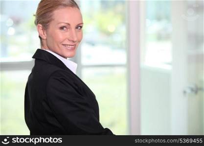 Portrait of a smiling woman in black suit