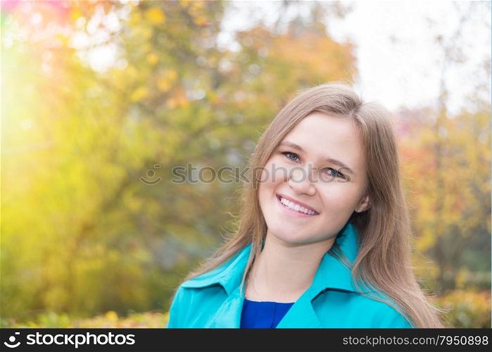 Portrait of a smiling young girl in the autumn nature close-up