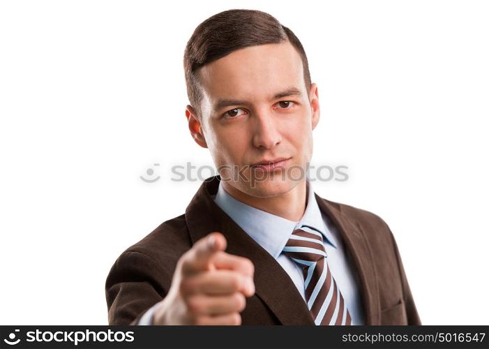 Portrait of a smiling young male business executive pointing at you against white background