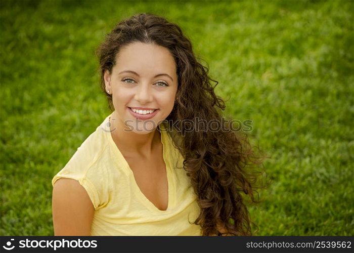 Portrait of a smiling young woman sitting on a blanket