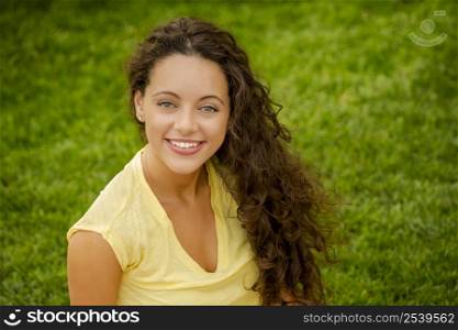 Portrait of a smiling young woman sitting on a blanket